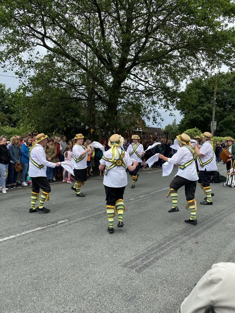 Leek Morris dancers performing in costume on a road
