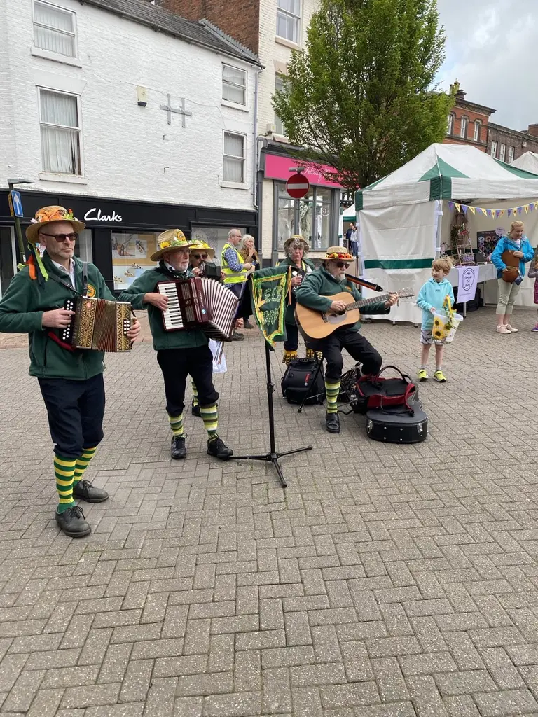 Leek Morris musicians playing on a street, in green costume